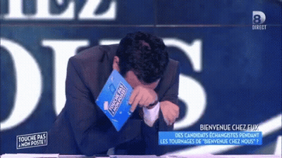 A Man In A Suit Is Crying While Holding A Book That Says Touche Pas Mon Poste GIF