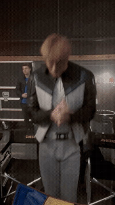 A Man In A Suit Is Dancing In Front Of A Box That Says Guest GIF