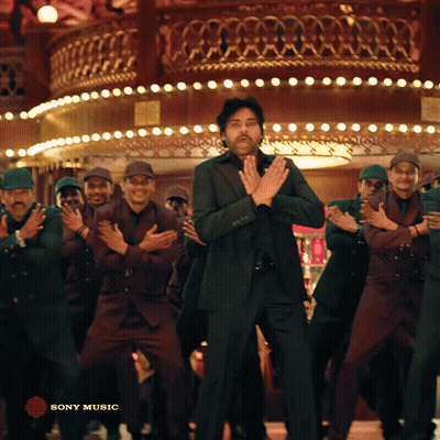 A Man In A Suit Is Dancing In Front Of A Group Of Men With Sony Music Written In The Corner GIF