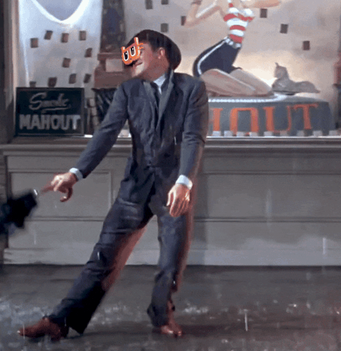 A Man In A Suit Is Dancing In The Rain In Front Of A Sign That Says Mahout GIF