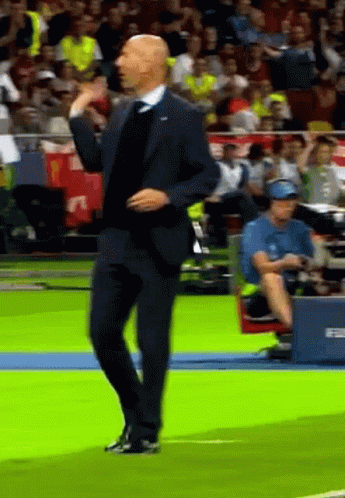A Man In A Suit Is Dancing On A Field GIF