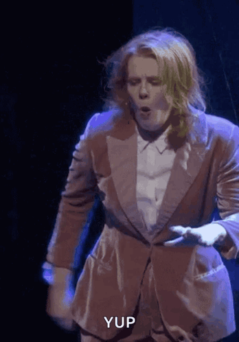 A Man In A Suit Is Dancing On A Stage And The Word Yup Is Visible In The Corner GIF