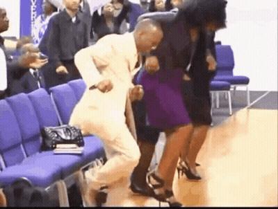 A Man In A Suit Is Dancing With A Woman In A Purple Dress In A Church . GIF