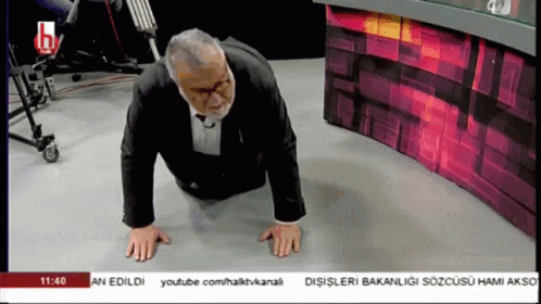 A Man In A Suit Is Doing Push Ups On The Floor In Front Of A Youtube Channel GIF