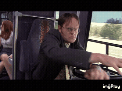 A Man In A Suit Is Driving A Bus With A Woman Sitting In The Back Seat GIF