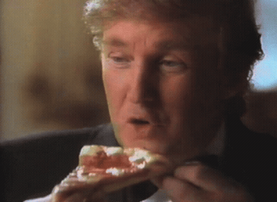 A Man In A Suit Is Eating A Piece Of Pizza GIF