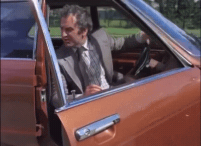 A Man In A Suit Is Getting Out Of A Car GIF