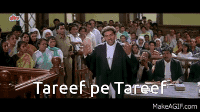 A Man In A Suit Is Giving A Speech In Front Of A Crowd With The Words " Tareef Pe Tareef " Written Below Him GIF