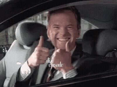 A Man In A Suit Is Giving A Thumbs Up In A Car GIF