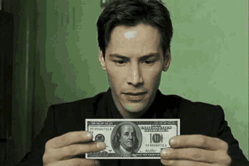 A Man In A Suit Is Holding A 10 Dollar Bill GIF