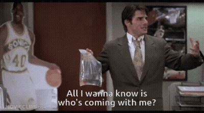 A Man In A Suit Is Holding A Bag And Says All I Wanna Know Is Who 'S Coming GIF