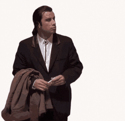 A Man In A Suit Is Holding A Brown Jacket GIF