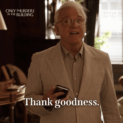 A Man In A Suit Is Holding A Cell Phone And Saying Thank Goodness GIF
