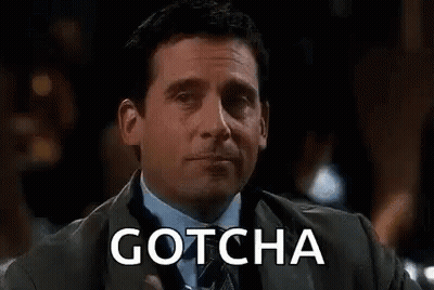 A Man In A Suit Is Holding A Glass Of Water And The Word Gotcha Is On The Screen Behind Him . GIF