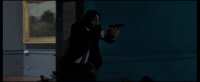 a man in a suit is holding a gun in front of a statue