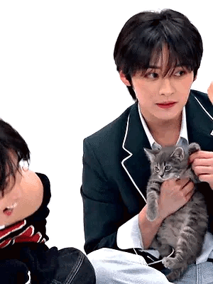A Man In A Suit Is Holding A Kitten In His Hands . GIF