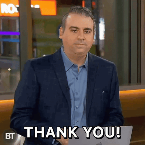 A Man In A Suit Is Holding A Laptop And Saying Thank You GIF