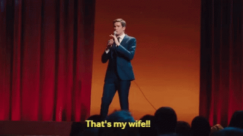 A Man In A Suit Is Holding A Microphone And Saying That 'S My Wife . GIF