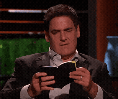 a man in a suit is holding a pen and a piece of paper