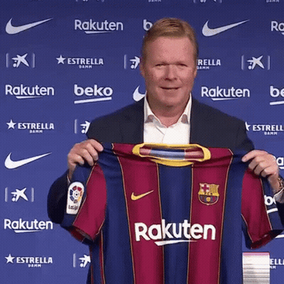 A Man In A Suit Is Holding A Rakuten Jersey In Front Of A Blue Wall . GIF