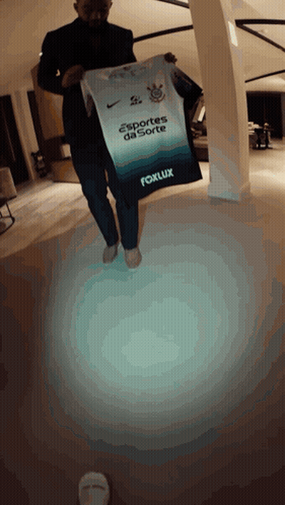 A Man In A Suit Is Holding A Sports Da Sorte Shirt GIF