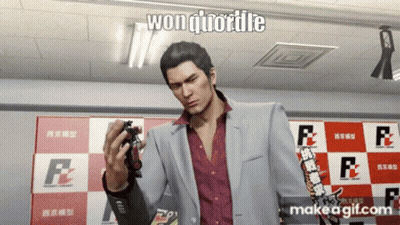 A Man In A Suit Is Holding A Toy In Front Of A Checkered Wall That Says F2 GIF