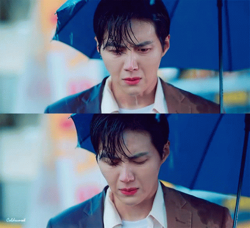 A Man In A Suit Is Holding An Umbrella And Crying In The Rain . GIF