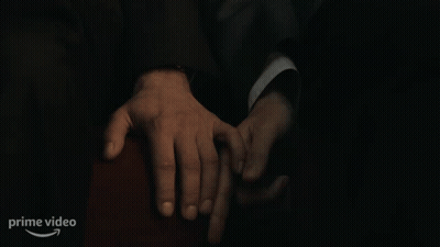 A Man In A Suit Is Holding Another Man 'S Hand In A Dark Room With A Prime Video Logo In The Corner GIF