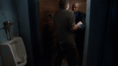 A Man In A Suit Is Holding Another Man 'S Neck GIF