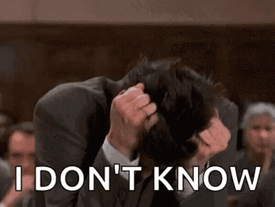 A Man In A Suit Is Holding His Head And Says `` I Don T Know '' . GIF