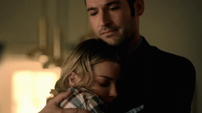 A Man In A Suit Is Hugging A Woman In A Plaid Shirt In A Dark Room GIF