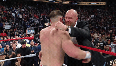 A Man In A Suit Is Hugging Another Man In A Ring GIF