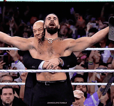 A Man In A Suit Is Hugging Another Man In A Wrestling Ring With The Words Jonmoxleys.tumblr Written Below GIF