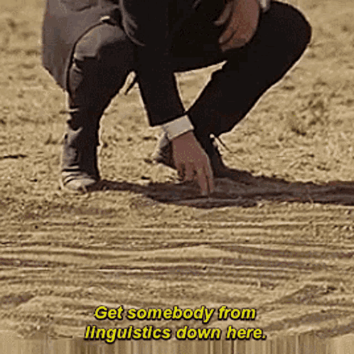 A Man In A Suit Is Kneeling Down In The Dirt With The Words Get Somebody From Linguistics Down Here GIF