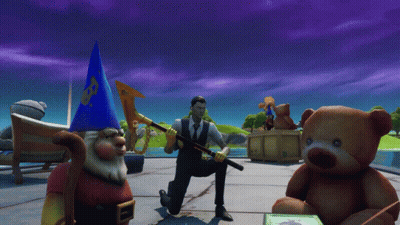 A Man In A Suit Is Kneeling Down Next To A Teddy Bear And A Gnome GIF