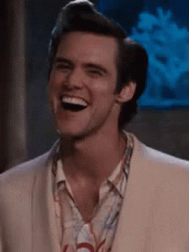 A Man In A Suit Is Laughing And Smiling . GIF