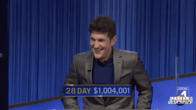A Man In A Suit Is Laughing While Playing A Game Of Jeopardy GIF