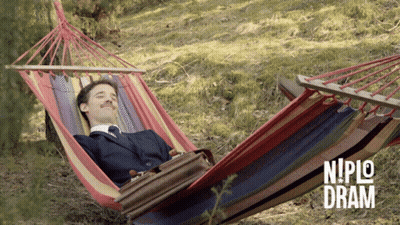 A Man In A Suit Is Laying In A Hammock With Niplo Dram Written On The Bottom Right GIF