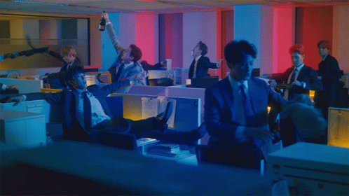 A Man In A Suit Is Laying On The Floor In An Office GIF