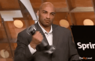 A Man In A Suit Is Lifting A Dumbbell In Front Of A Sign That Says Sprint . GIF