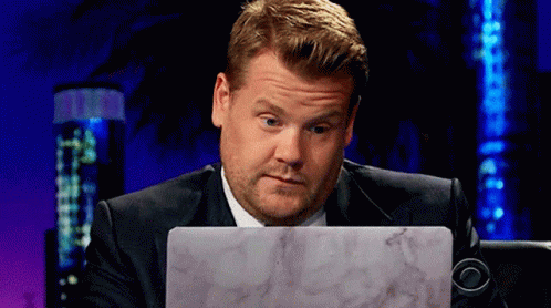 A Man In A Suit Is Looking At A Laptop Computer GIF