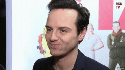 A Man In A Suit Is Making A Funny Face In Front Of A Rcn Tv Sign GIF