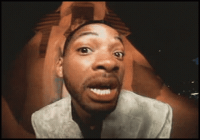 A Man In A Suit Is Making A Funny Face With His Mouth Open GIF