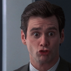 A Man In A Suit Is Making A Funny Face With His Mouth Open GIF