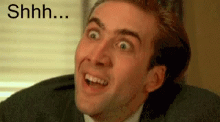 A Man In A Suit Is Making A Funny Face With His Mouth Open . GIF