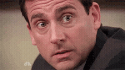 A Man In A Suit Is Making A Surprised Face . GIF
