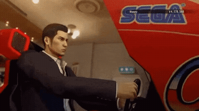 A Man In A Suit Is Playing A Video Game In Front Of A Sign That Says Sega GIF