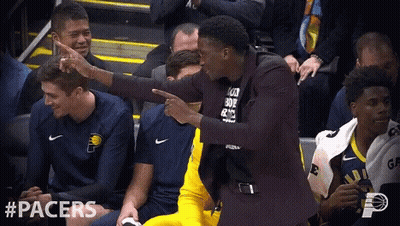 A Man In A Suit Is Pointing At Another Man In A Black Shirt That Says " I Love You " GIF