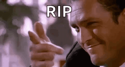 a man in a suit is pointing his finger at the camera and saying `` rip '' .