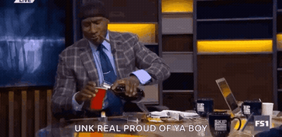 A Man In A Suit Is Pouring A Drink Into A Red Cup GIF